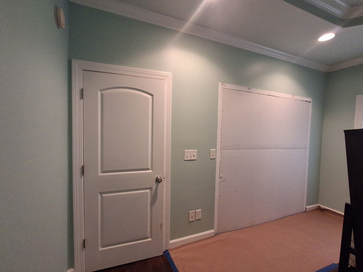Master bedroom during remodel with flooring removed and drywall patched
