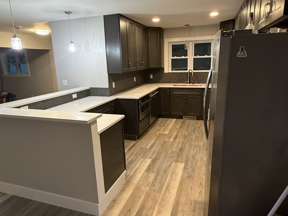 Open kitchen remodel with dark cabinets and new flooring