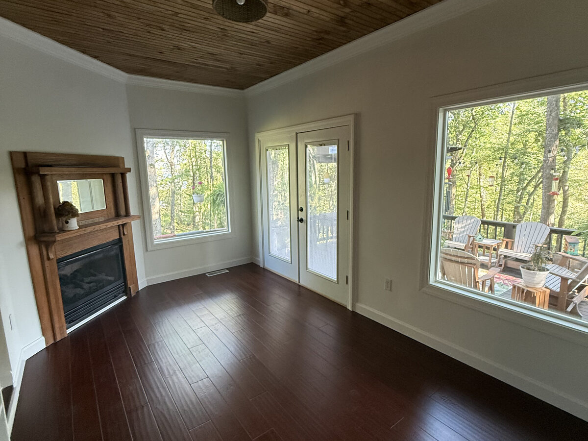 Finished living room with hardwood floors, fireplace and wood plank ceiling