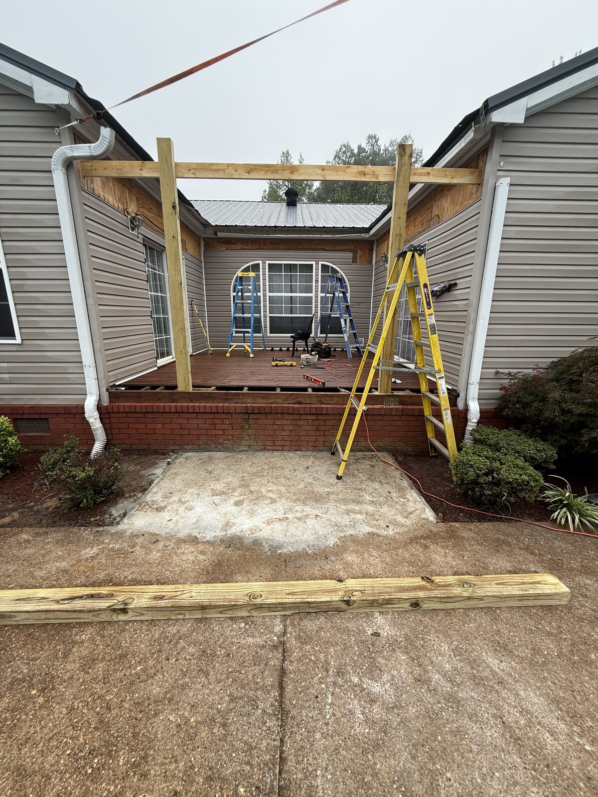 Before: porch framing in progress with posts and beams going up