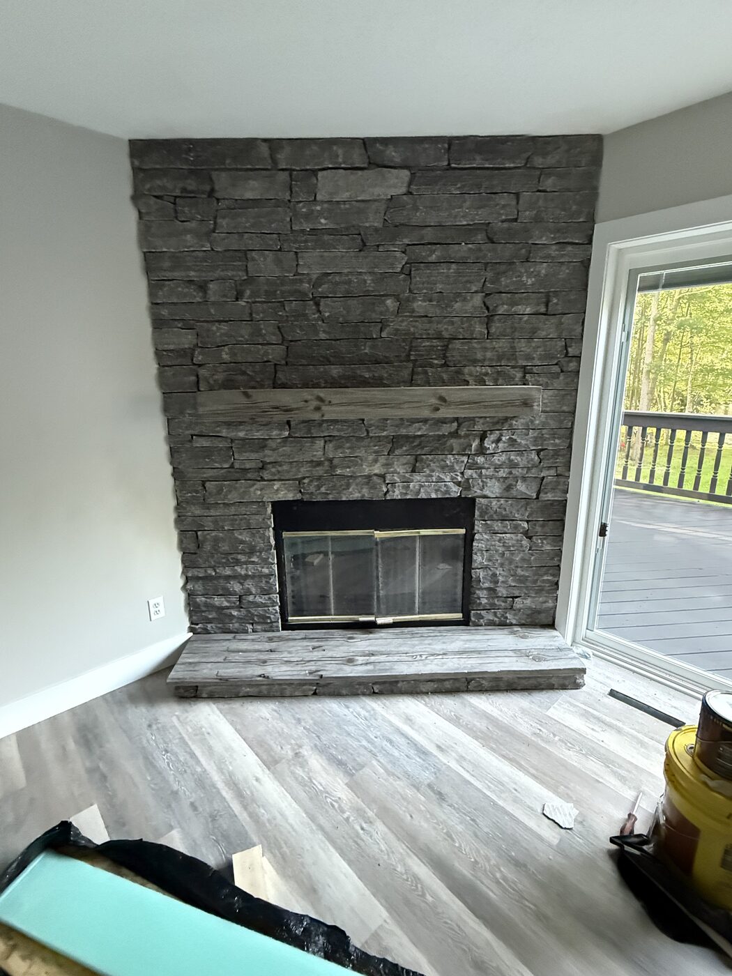 Stacked stone fireplace with reclaimed wood mantel and hearth